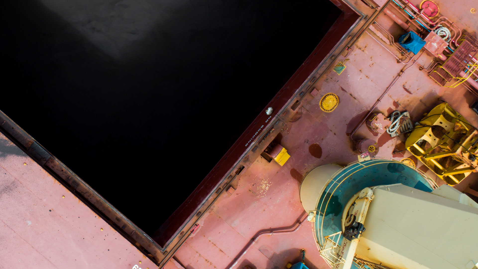 aerial view of a ship's deck showing a large empty cargo hold