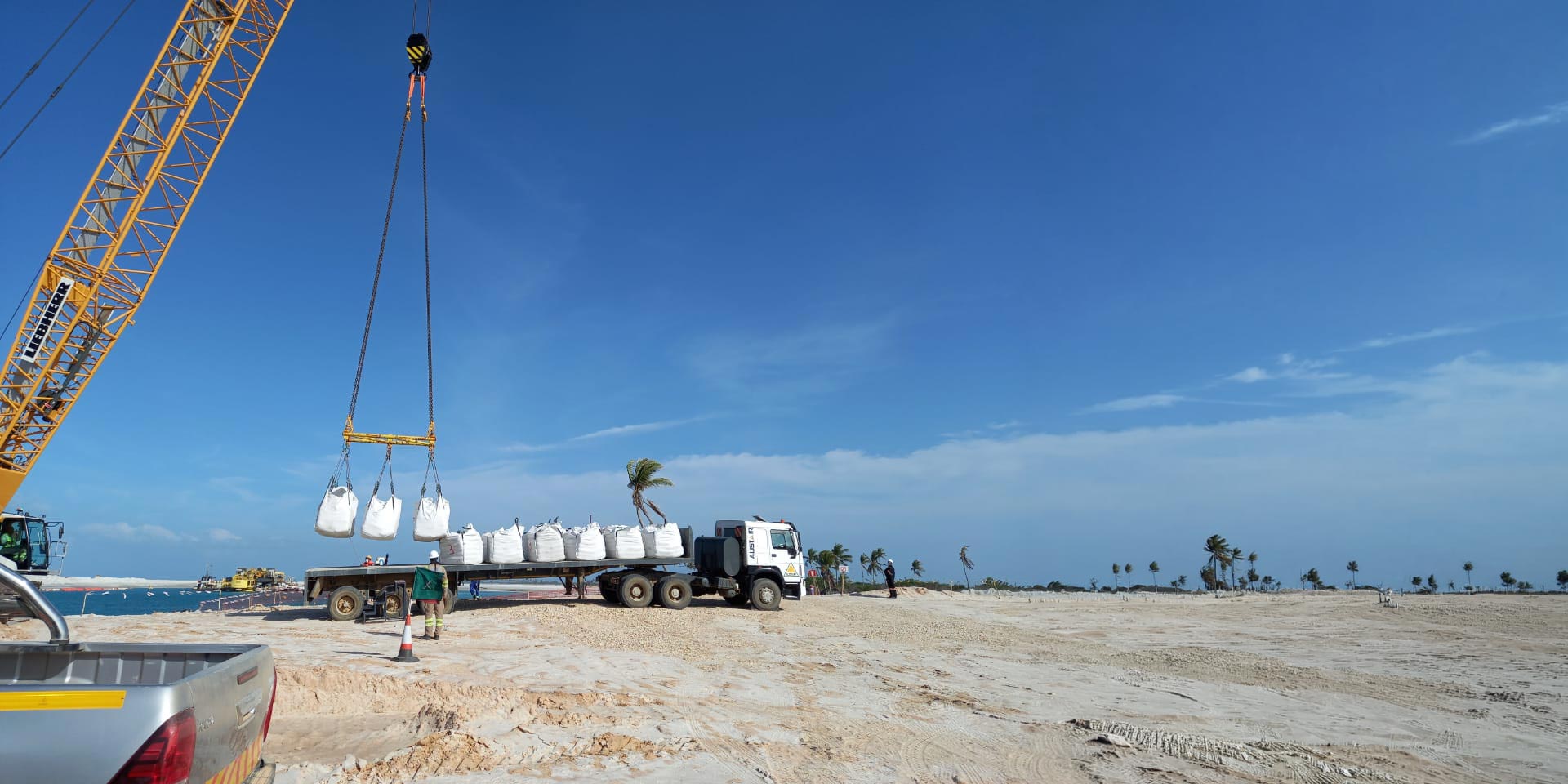 crane loading bulk material bags onto a flatbed truck